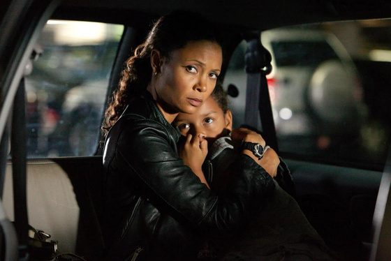 Scene from Rogue crime drama TV series.  Thandiwe Newton plays Grace and is cradling a frightened young child in the back seat of a car.